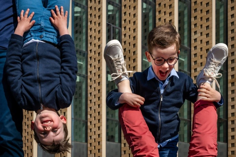 Deux garçons s’amusent, l’un porté la tête en bas