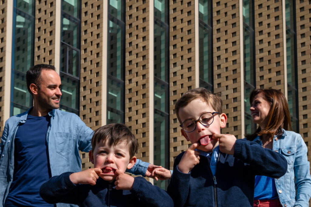 Deux garçons font des grimaces avec leurs parents derrière eux