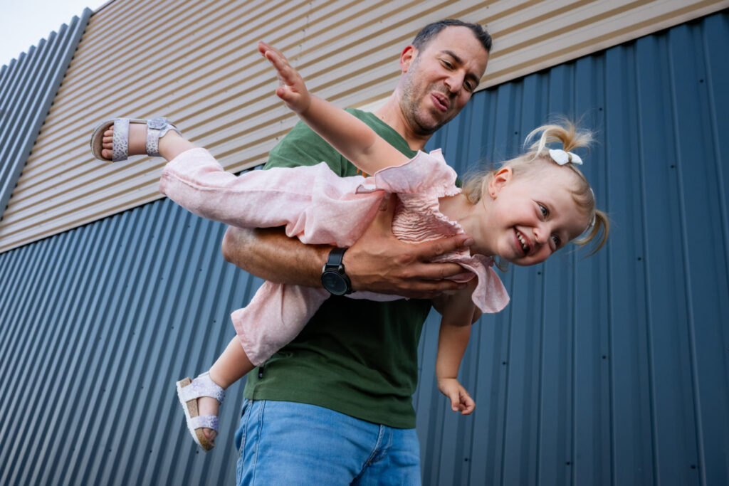 Un père fait voler sa petite fille dans ses bras