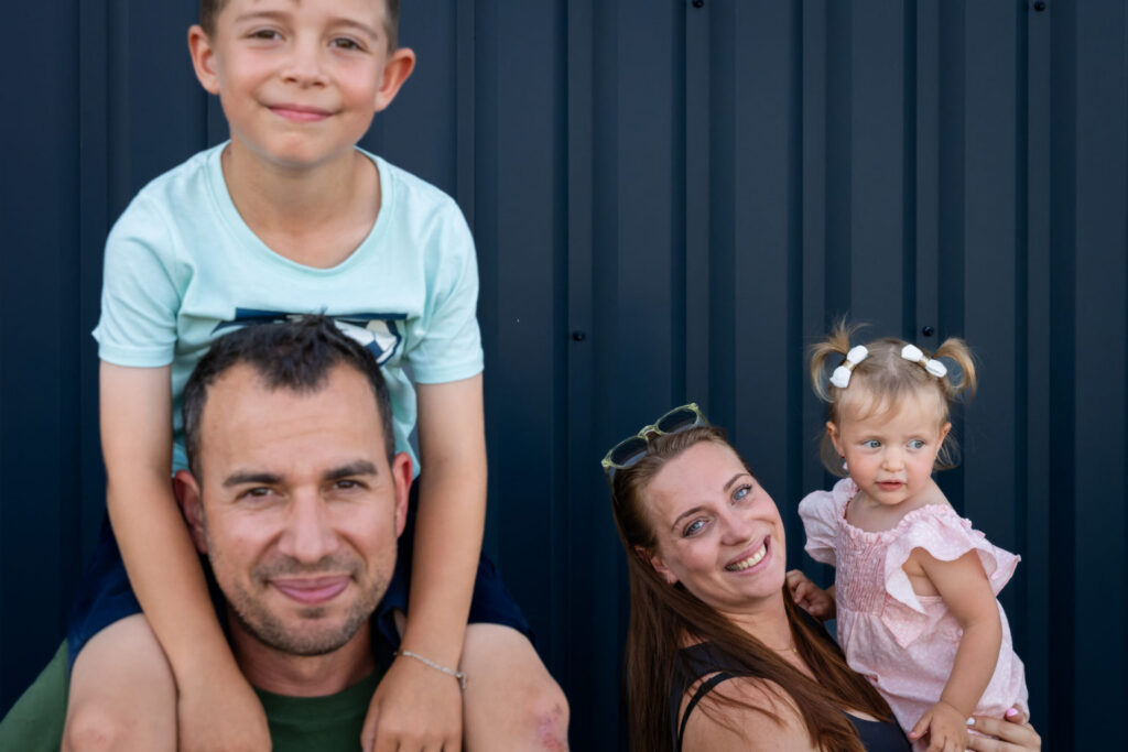 Un garçon sur les épaules de son père, à côté de sa mère et d’une petite fille