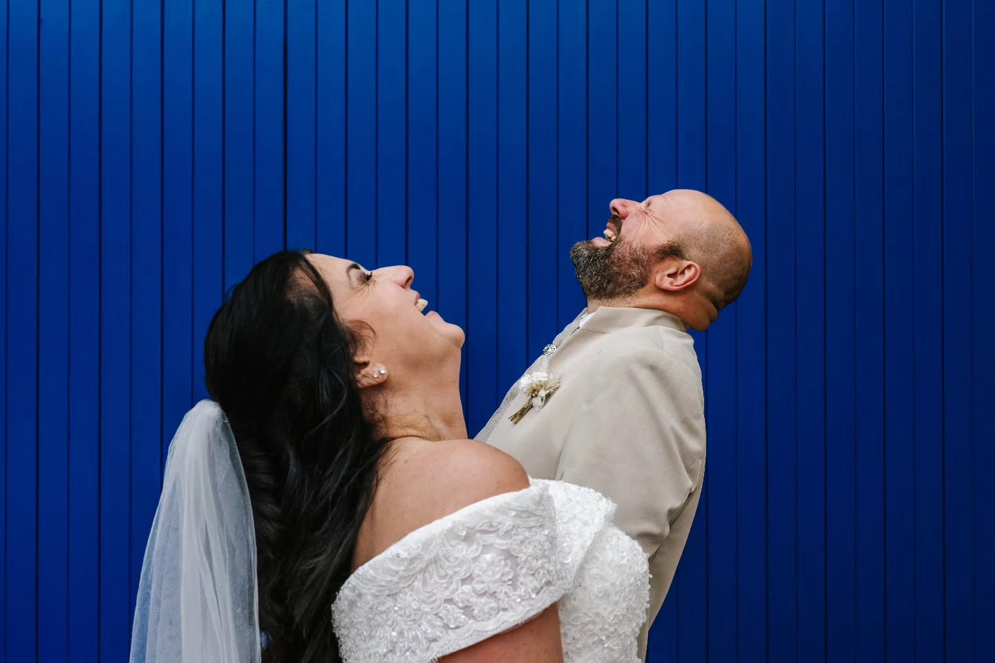 Priscillia et Patrice éclatent de rire devant une porte bleue pendant leur séance de couple à Hattonchâtel.