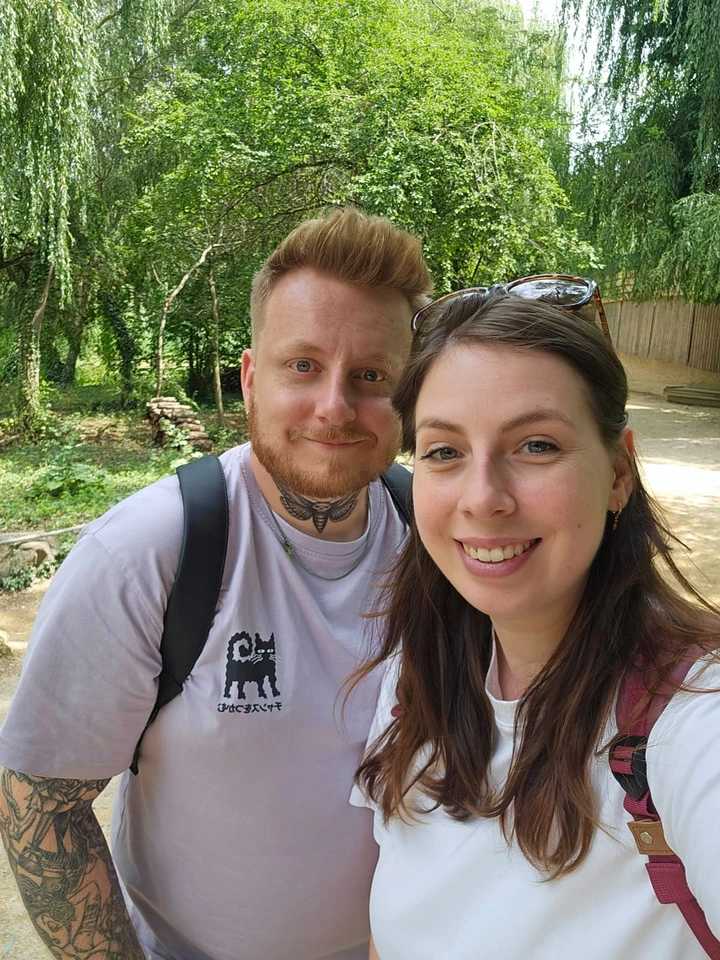 Jonathan et sa compagne sourient pour un selfie en extérieur