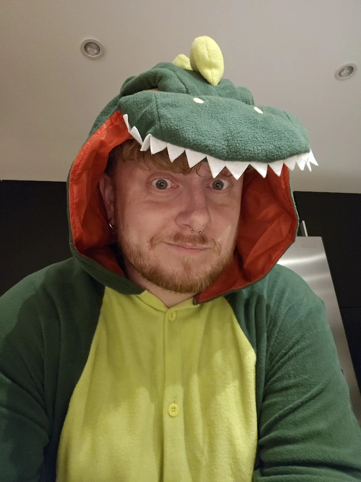 Jonathan fait un selfie dans un déguisement vert de dinosaure