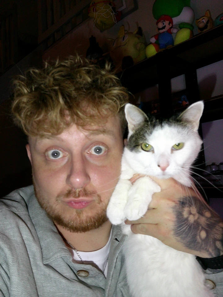 Jonathan et son chat blanc et tigré, les yeux grands ouverts