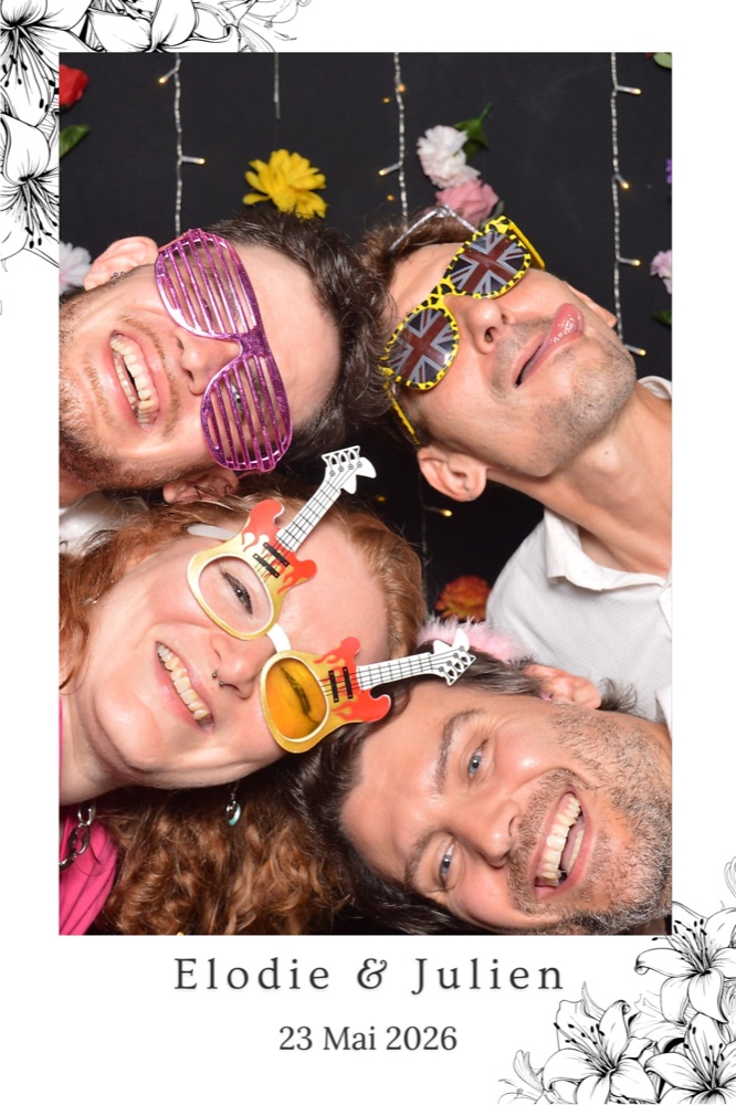 Quatre invités prennent la pose avec des lunettes fantaisie dans un cadre floral