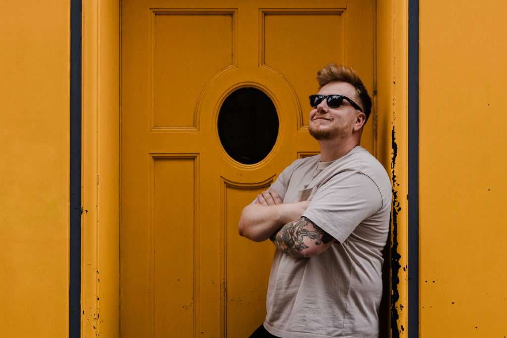 Portrait de Jonathan Gabel devant une porte